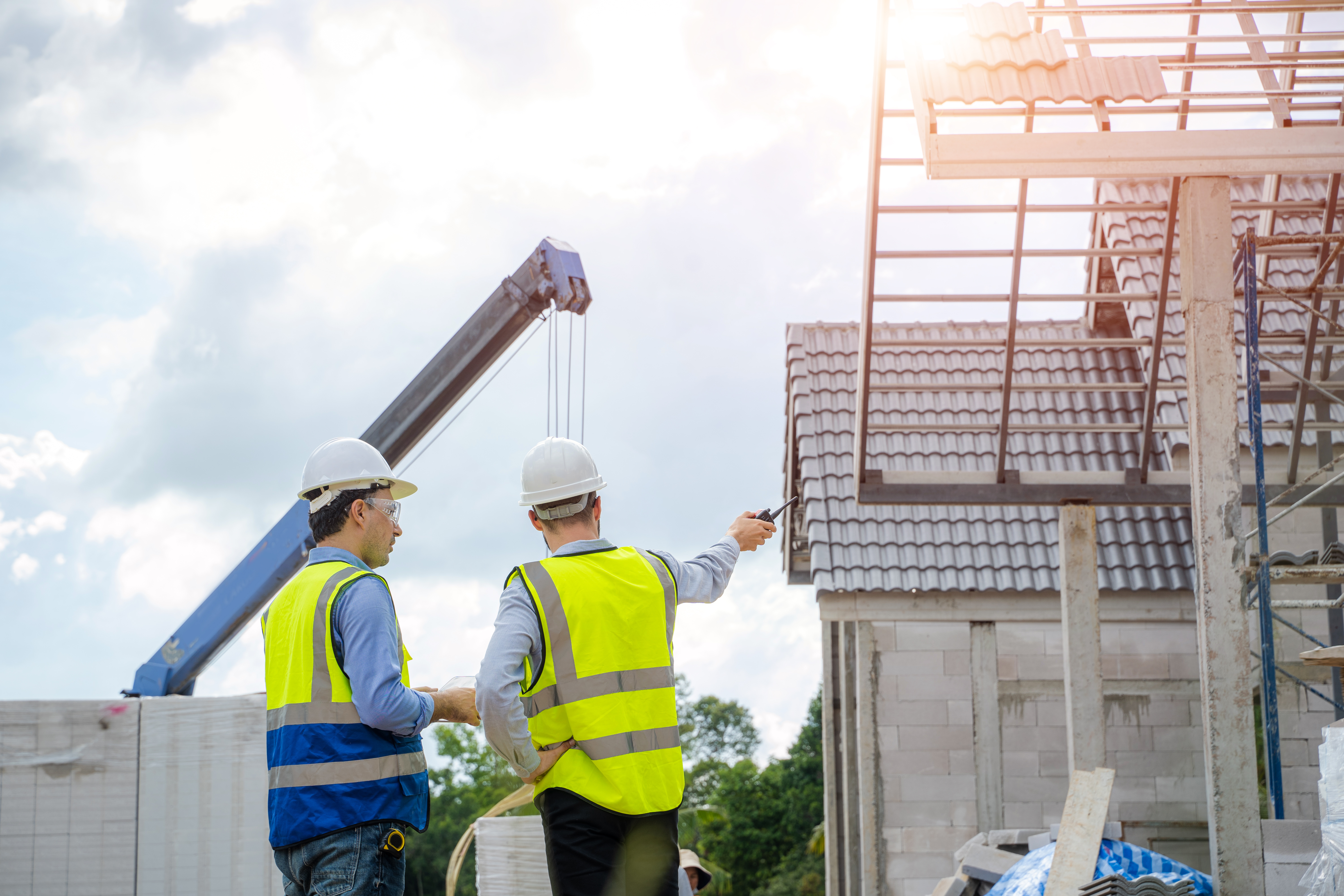 Engineer use tablet working with new house on construction site,Construction residential new house in progress at building site.